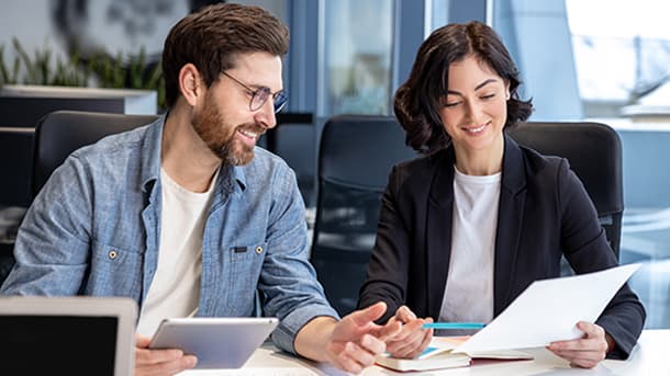 Two business people reviewing content on a tablet.
